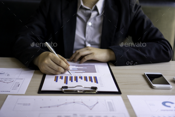 Asian female chief financial officer pointing at documents Company performance based on numbers and