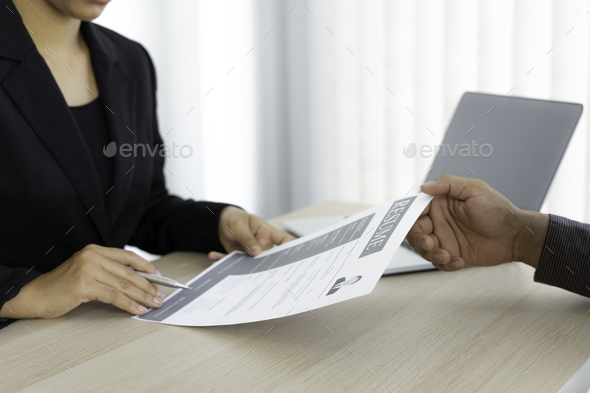 Male job applicants are submitting a resume to the head of the HR department inside the job intervie