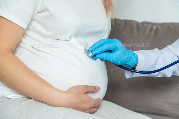 The doctor examines the belly of a pregnant woman. Selective focus. - Stock Photo - Images