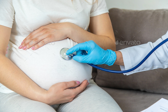The doctor examines the belly of a pregnant woman. Selective focus. - Stock Photo - Images