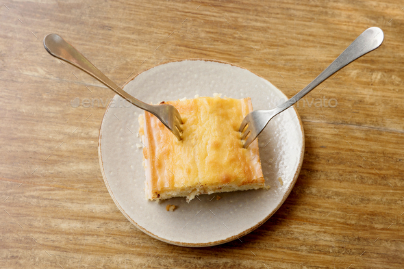 Sharing a piece of lemon cake with two forks and copy space on wood table