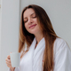 Relaxed Asian woman wearing bath robe drinking coffee in hotel room in morning - PhotoDune Item for Sale