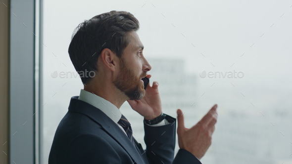 Manager have telephone conversation with partners at panoramic window close up
