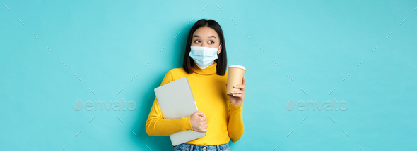 covid-19, health care and quarantine concept. Asian girl student in medical mask standing with