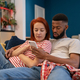 Young millennial diverse couple man and woman resting at home with mobile phone - PhotoDune Item for Sale