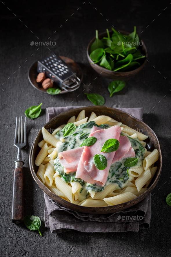 Delicious and fresh penne with spinach and bechamel sauce. - Stock Photo - Images