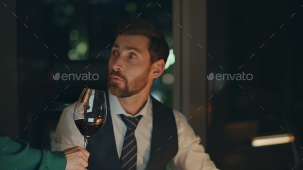 Woman bringing wine businessman focused on work at night closeup. Happy partners - Stock Photo - Images