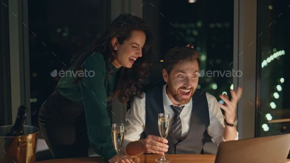 Business team celebrating success with champagne looking on laptop close up. - Stock Photo - Images
