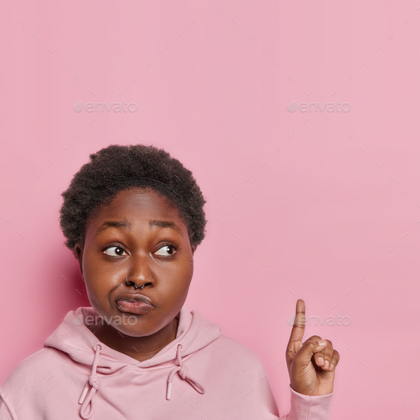 Marketing promotions advertising and retail concept. Young black woman points upwards gestures