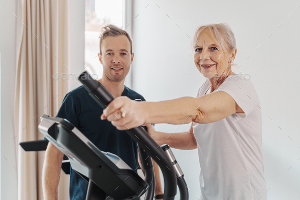 Smiling senior woman and his personal triner working out