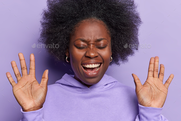 Headshot Of Emotional Dark Skinned Woman With Dark Bushy Hair Keeps Palms Raised Up Exclaims 2189