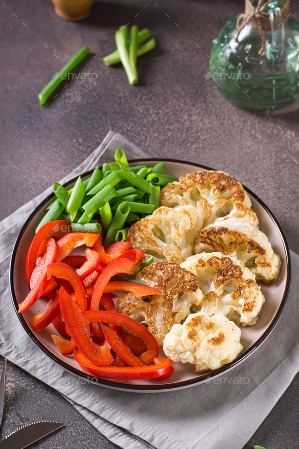 Roasted cauliflower, bell peppers and chives in a veggie bowl vertical view