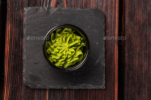 Green wasabi sauce or paste in bowl on wooden background top view - Stock Photo - Images