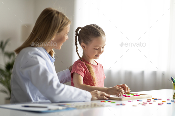 Vocabulary Building. Little Girl Making Words With Colorful Letters During Therapy Session