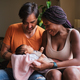Multiethnic couple with a newborn in arms at home - PhotoDune Item for Sale