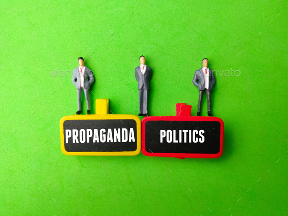 Miniature people and wooden board with the word PROPAGANDA POLITICS - Stock Photo - Images