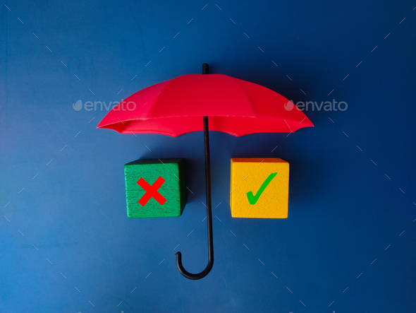 Red umbrella and colored cube with sign wrong and right on blue background. - Stock Photo - Images