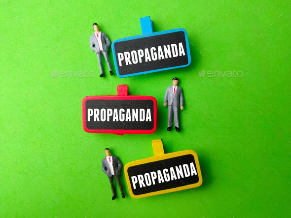 Miniature people and wooden board with the word PROPAGANDA on green background. - Stock Photo - Images
