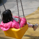  child having fun on a swing on the playground in public park. - PhotoDune Item for Sale