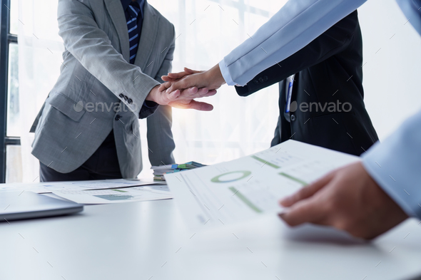 Group of business people putting their hands working together on wooden background in office. group - Stock Photo - Images