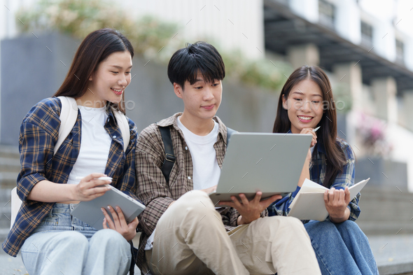 Young Asian woman college student with friends at outdoors. College student working on the college - Stock Photo - Images
