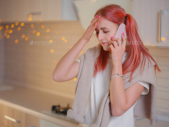 Young beautiful caucasian woman using cell phone in kitchen - Stock Photo - Images
