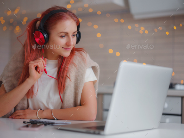 attractive young woman working with laptop in kitchen - Stock Photo - Images