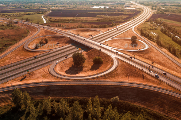 Aerial shot of freeway loop with many vehicles driving in various directions, drone pov - Stock Photo - Images