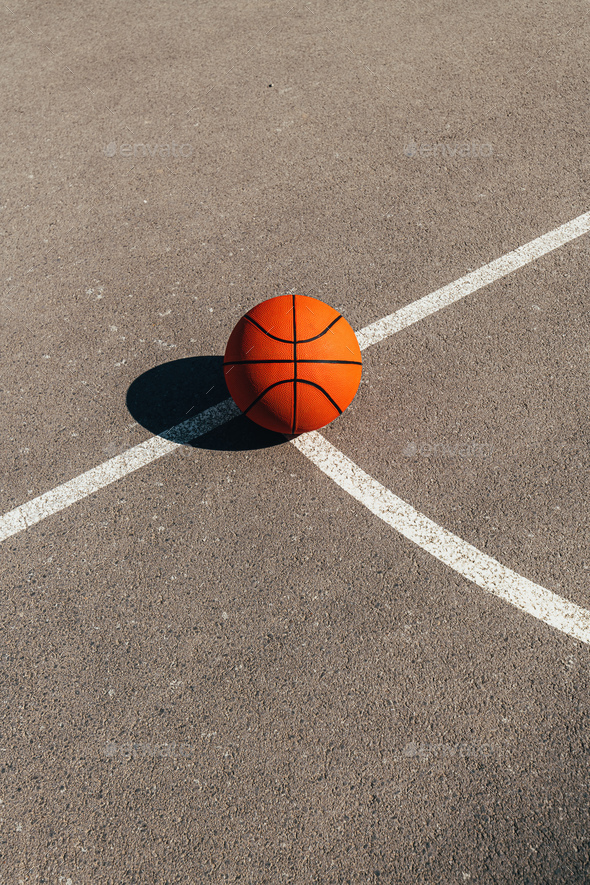 Basketball ball on outdoor court with asphalt surface - Stock Photo - Images