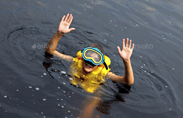Happy young boy swimming in lake - Stock Photo - Images