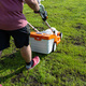 A man mows the grass with an orange electric mower. - PhotoDune Item for Sale
