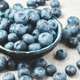 Blueberries with water drops in a ceramic bowl and scattered around. - PhotoDune Item for Sale