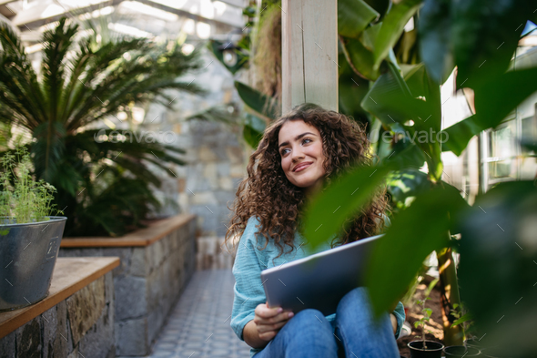 Portrait of young woman in botanical garden. - Stock Photo - Images
