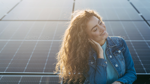 Portrait of young woman on roof with solar panels. - Stock Photo - Images