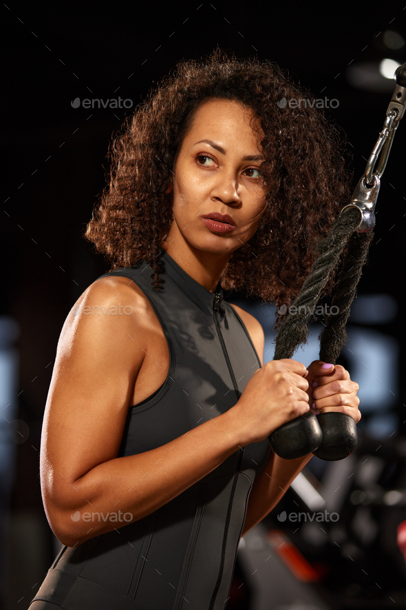 African American woman doing triceps exercises in the gym, close-up,  cardio, weight loss, beautiful Stock Photo by Gerain0812