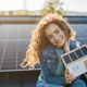 Portrait of young woman on roof with solar panels, holding model of house with photovoltaics. - PhotoDune Item for Sale