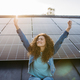 Portrait of young excited woman on roof with solar panels. - PhotoDune Item for Sale