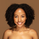 Attractive black woman with bushy hair posing naked on brown - PhotoDune Item for Sale