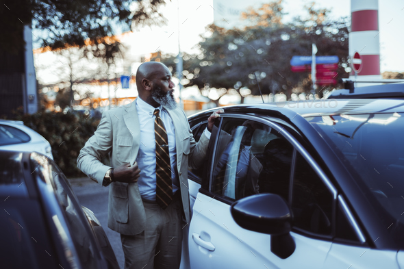 Black Man Adjusts Jacket near Car - Stock Photo - Images