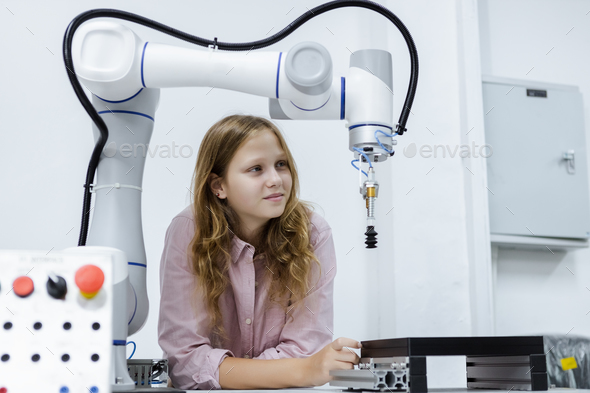 Girl caucasoid education electronic robotic arm on table at class room.