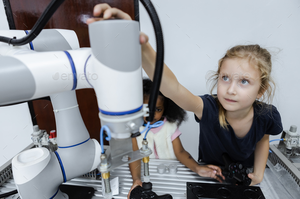 Girl Caucasoid education electronic robotic arm on table at class room.