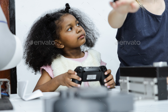 Children girl African American holding joystick education electronic on table at class room