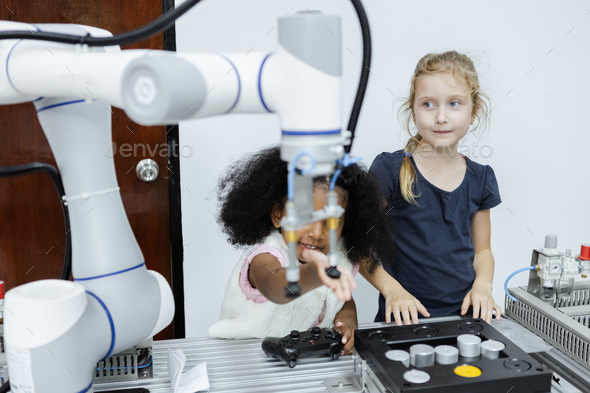 Children girl caucasoid and girl African American education electronic robotic arm on table at class