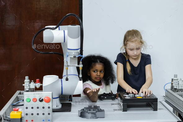 Children girl Caucasoid and girl African American education electronic robotic arm on table at class