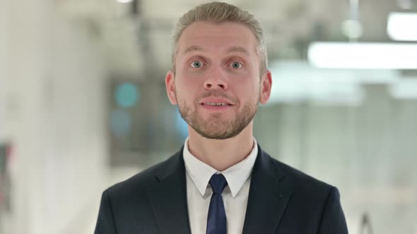 Portrait of Positive Businessman Saying Yes By Shaking Head alt