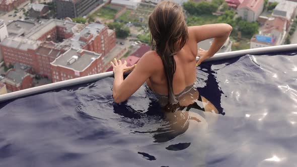 Attractive Woman in Swimming Pool on Roof