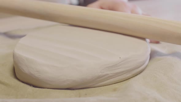 Unrecognizable Craftswoman Using Rolling Pin in Workshop alt