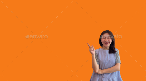 Asian woman pointing finger inviting click here - Stock Photo - Images