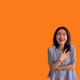 Asian woman laughing happily on orange background - PhotoDune Item for Sale