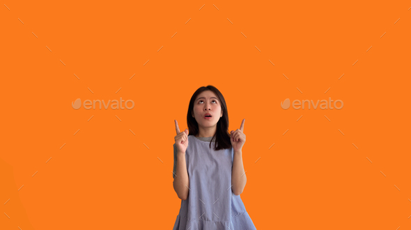 Asian woman pointing finger inviting click here - Stock Photo - Images